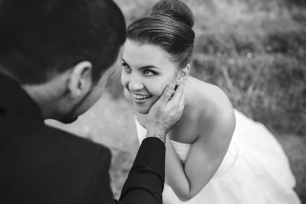 Brudgummen vidrör försiktigt ansiktet på sin brud — Stockfoto