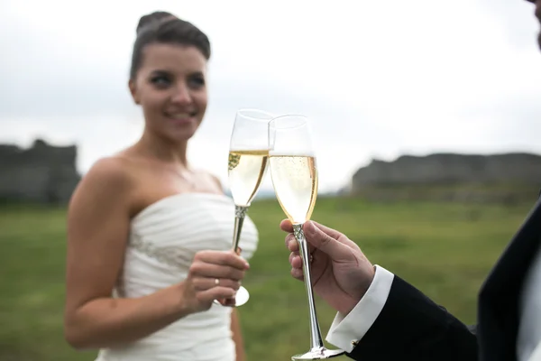 Bruidspaar clink glazen van champagne — Stockfoto