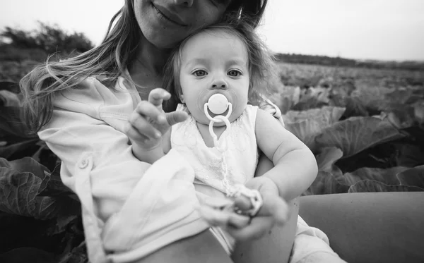 Mother and daughter on the field with cabbage — Stock Photo, Image