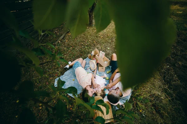 Lycklig familj på gräsmattan i parken — Stockfoto