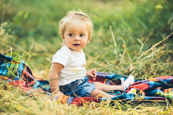 Malá dívka sedící na trávníku — Stock fotografie