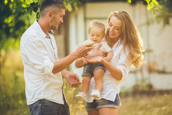 Familjer med ett barn i sommarträdgården — Stockfoto