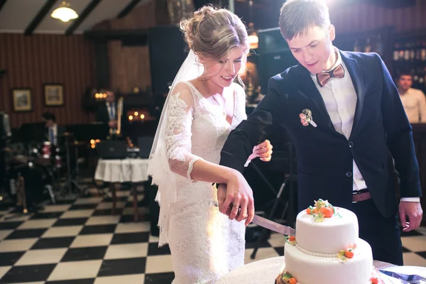 Braut und Bräutigam schneiden Kuchen an — Stockfoto