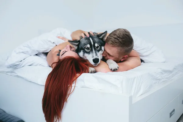 Jovem casal adulto deitado na cama — Fotografia de Stock