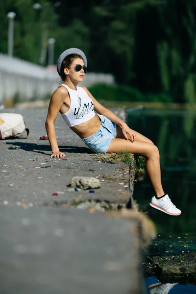 Schönes Mädchen sitzt auf der Seebrücke — Stockfoto