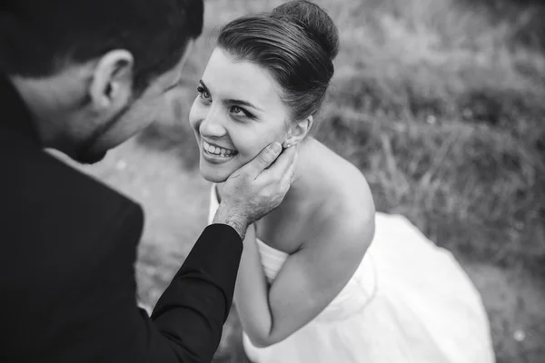 Brudgummen vidrör försiktigt ansiktet på sin brud — Stockfoto