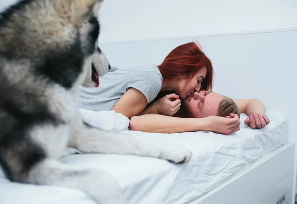 Jovem casal adulto deitado na cama — Fotografia de Stock