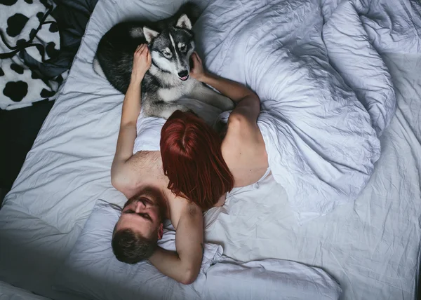 Молодая взрослая пара лежит на кровати — стоковое фото