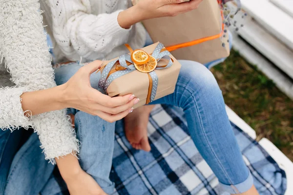 Les filles s'assoient sur un banc et tirent des cadeaux — Photo