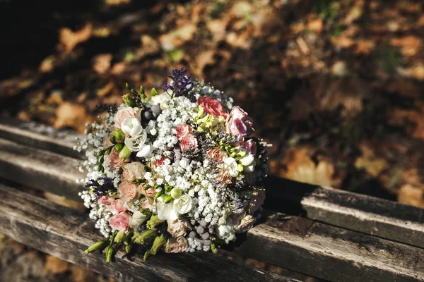 Beautiful bridal bouquet lying on a bench — Stock Photo, Image