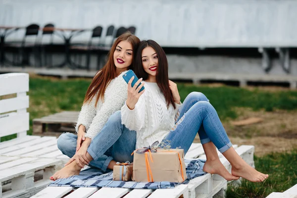 Две девушки делают селфи с подарками — стоковое фото
