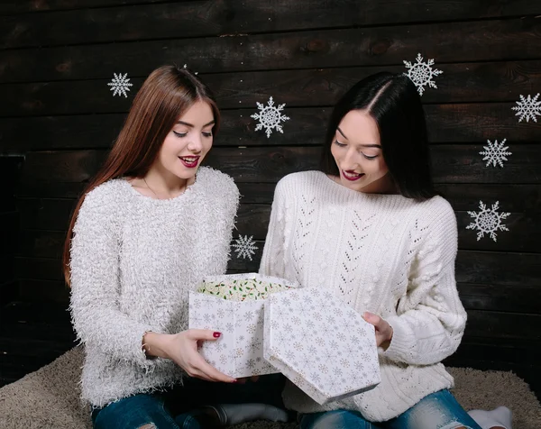 Dos hermosas chicas juntas desempaquetan regalos —  Fotos de Stock