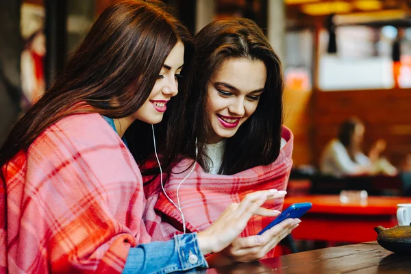 Två flickor lyssna på musik med en smartphone — Stockfoto