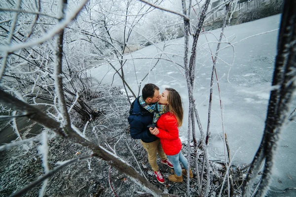 Hermosa pareja posando cerca de un río congelado — Foto de Stock