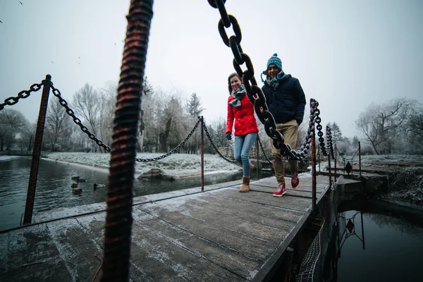 Mooi paar treedt een kleine brug — Stockfoto