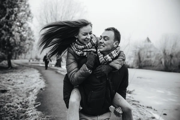 Člověk nese svou přítelkyni na zádech — Stock fotografie