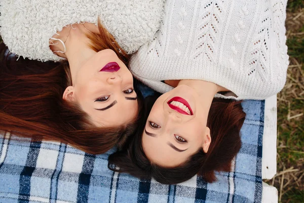 Две красивые девушки лежат на скамейке — стоковое фото