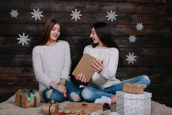 Dwie piękne dziewczyny z tabletem, między prezenty — Zdjęcie stockowe