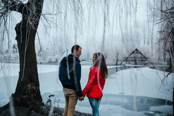 Beau couple posant près d'une rivière gelée — Photo