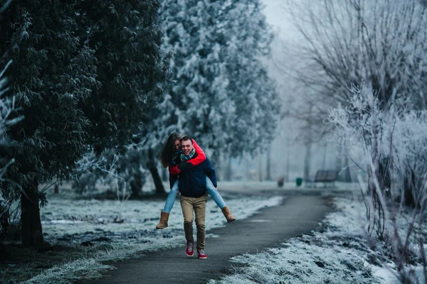Člověk nese svou přítelkyni na zádech — Stock fotografie