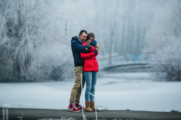 Hermosa pareja posando cerca de un río congelado —  Fotos de Stock