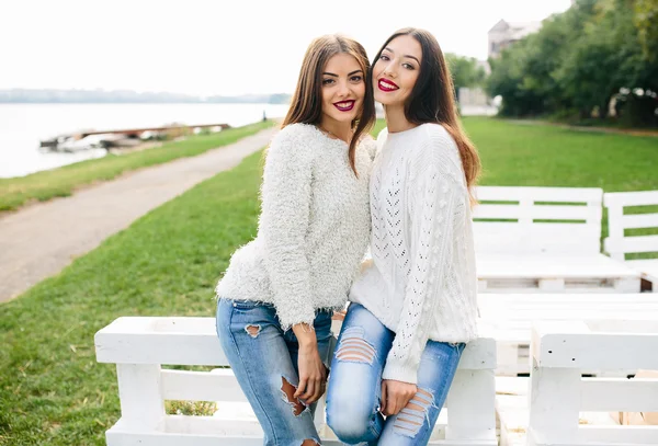 Dos chicas se inclinan banco — Foto de Stock