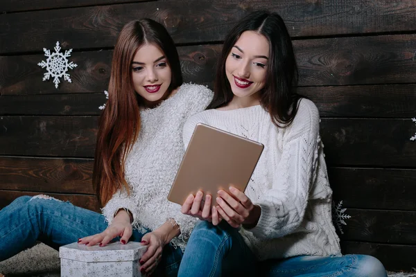 Två vackra flickor med en tablett, mellan gåvor — Stockfoto
