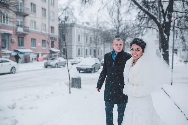 Noiva e noivo andando na neve — Fotografia de Stock