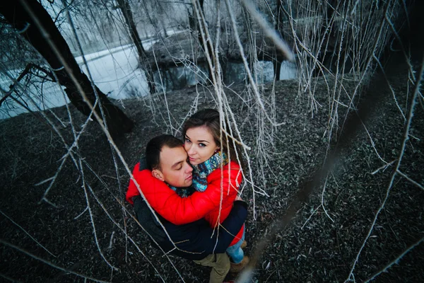 Beautiful couple posing near a frozen river — Stock Photo, Image