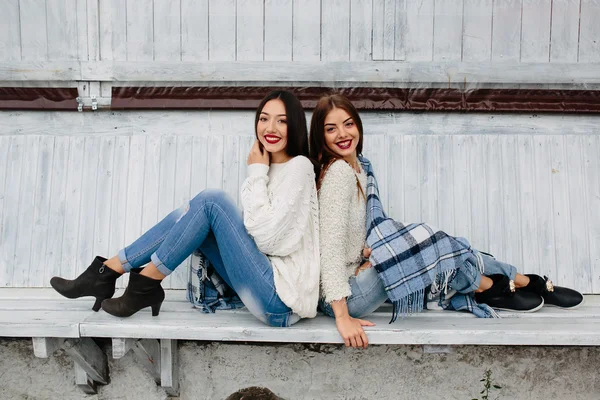 Dvě dívky sedí na lavičce v parku — Stock fotografie