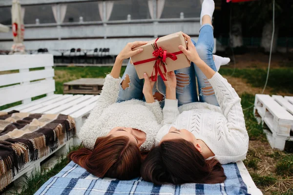 Las niñas mienten y desempaca un regalo — Foto de Stock