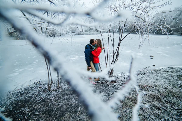 Bella coppia posa vicino a un fiume ghiacciato — Foto Stock