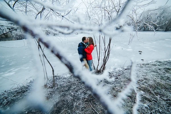 Hermosa pareja posando cerca de un río congelado — Foto de Stock