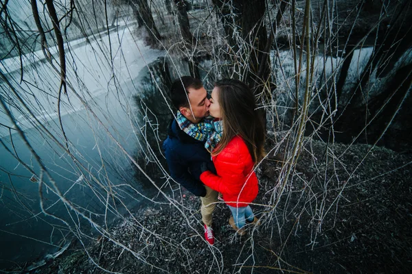 Belo casal posando perto de um rio congelado — Fotografia de Stock