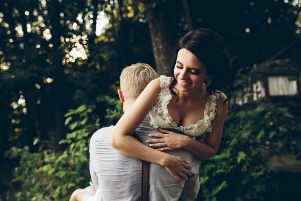 Sposo tiene sposa tra le braccia — Foto Stock