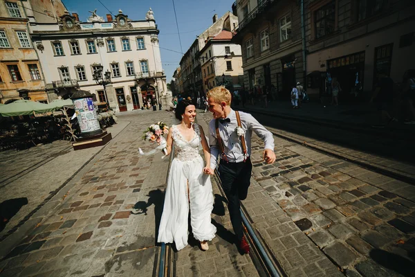 La novia y el novio corriendo por las calles —  Fotos de Stock