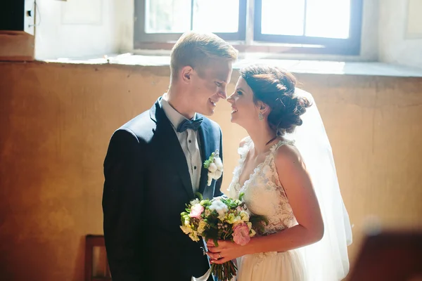 Nevěsta a ženich na pozadí okna. — Stock fotografie