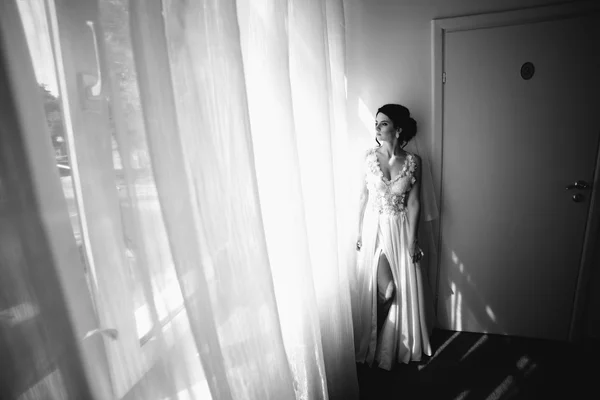 Noiva posando em uma grande janela — Fotografia de Stock