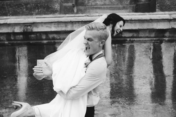 Γαμπρός μεταφέρει την νύφη στην αγκαλιά του — Φωτογραφία Αρχείου