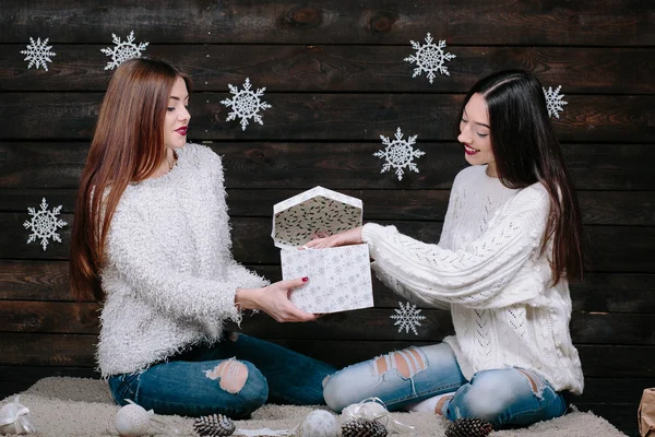 Dos chicas jóvenes sosteniendo brillante regalo de vacaciones —  Fotos de Stock
