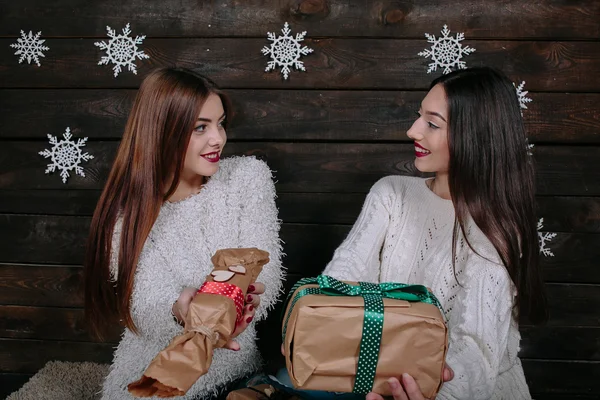 Dos hermosas chicas ofrecen regalos a la cámara —  Fotos de Stock