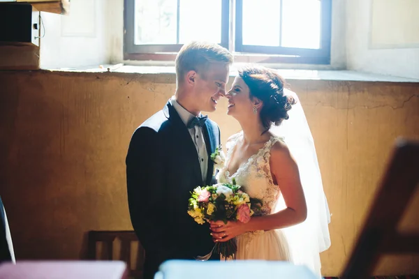 Bride and groom on the background of a window. — Stock Photo, Image