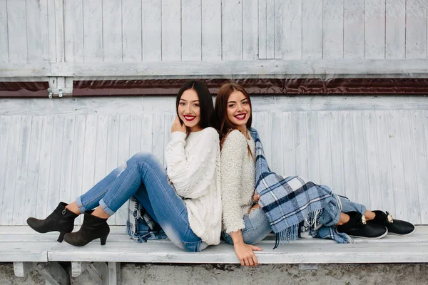 Dvě dívky sedí na lavičce v parku — Stock fotografie