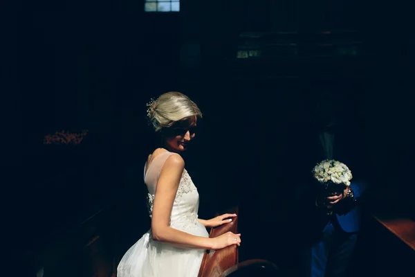 Bride and groom illuminated by light — Stock Photo, Image