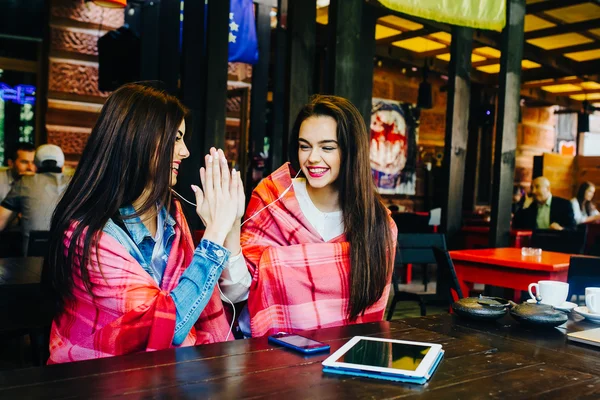 Две молодые и красивые девушки веселятся в кафе — стоковое фото
