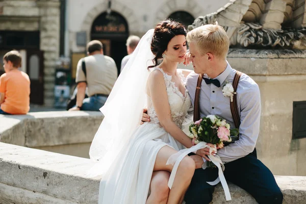 Novia y novio posando en la fuente — Foto de Stock