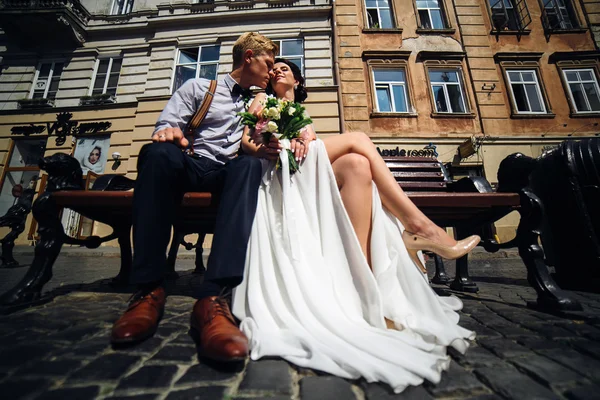 Noiva e noivo sentar no banco — Fotografia de Stock