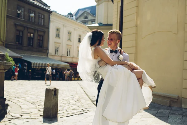 Vőlegény menyasszony hordozza a karját — Stock Fotó