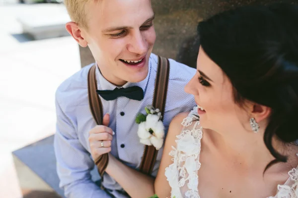 Hochzeitspaar sitzt auf einer Steinbank — Stockfoto