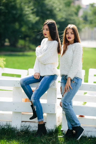 Twee meisjes leunen Bank — Stockfoto